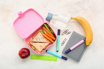 Stationery, drink and lunch box with tasty food on grunge light background