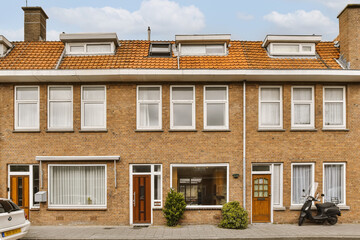 a row of houses with parked cars on the street in front of them and two moped motor scoots