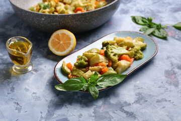 Plate with different vegetables on blue background