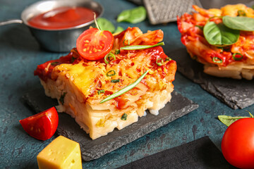 Boards of pasta with tomato sauce and cheese on dark background