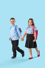 Obraz premium Little schoolchildren holding hands on light blue background