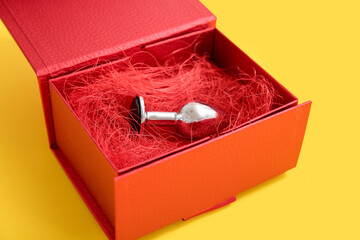 Anal plug in gift box on yellow background
