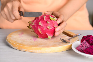 Red dragon fruit or pitaya with hand holding knife to cutting, Tropical fruit in summer season