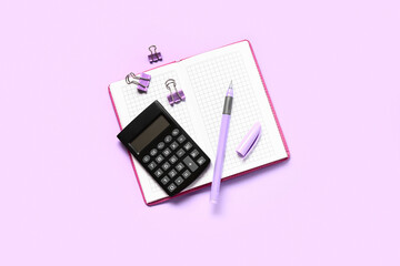 Modern calculator with stationery on lilac background