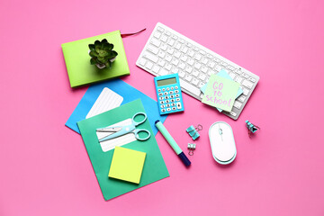 Sticky note with text GO TO SCHOOL, calculator, keyboard and stationery on pink background