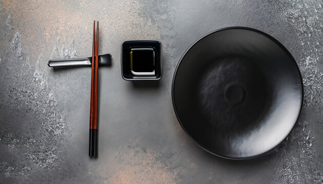 Set of dark plates and chopsticks on stone background. Set for Asian, Japanese and Chinese food. Horizontal banner - Image