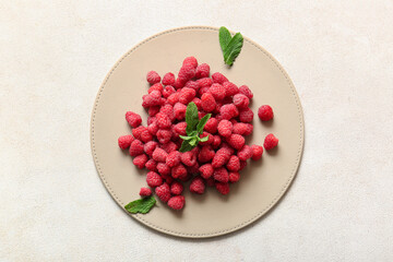 Heap of fresh raspberries and mint on white background