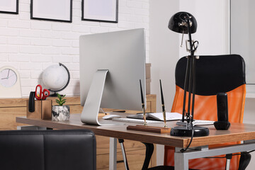 Stylish director's workplace with comfortable furniture, computer and accessories in office. Interior design