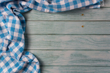Obraz premium Blue checkered tablecloth on wooden table in blue color