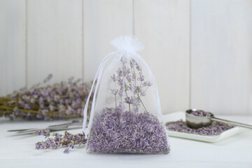 Scented sachet with dried lavender flowers on white table