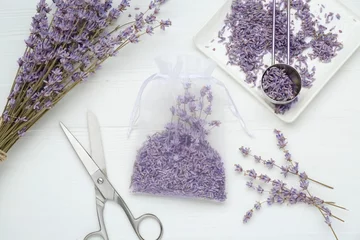 Möbelaufkleber Scented sachet with dried lavender flowers and scissors on white wooden table, flat lay © New Africa