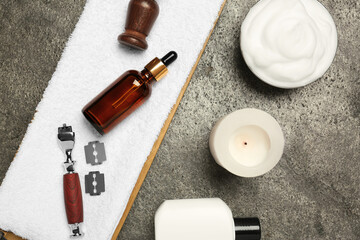 Different shaving accessories for men and candle on grey table, flat lay