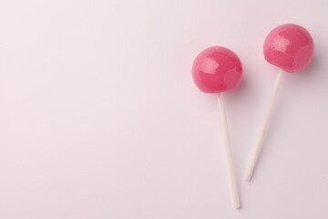 Tasty lollipops on white background, flat lay. Space for text