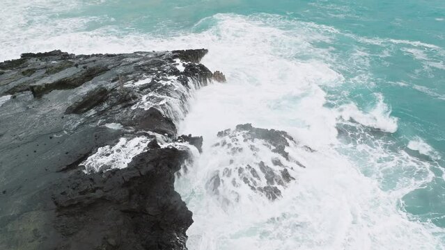 Scenic view on Halona Blowhole. Beautiful sea waves pushed through the hole in the sea rock and throwing up splashes of water like fountain. Amazing natural event, tourist attraction on Oahu island.