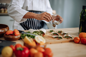 The skilled master chef prepares a vegetable wrap with great passion and care. Mix all the ingredients and materials carefully and precisely with expertise. Served with a flavorful sauce on top.
