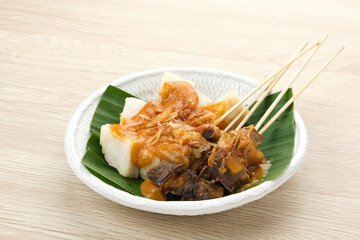 Sate Padang, beef satay from West Sumatra, Indonesia, served with spicy curry sauce and ketupat
