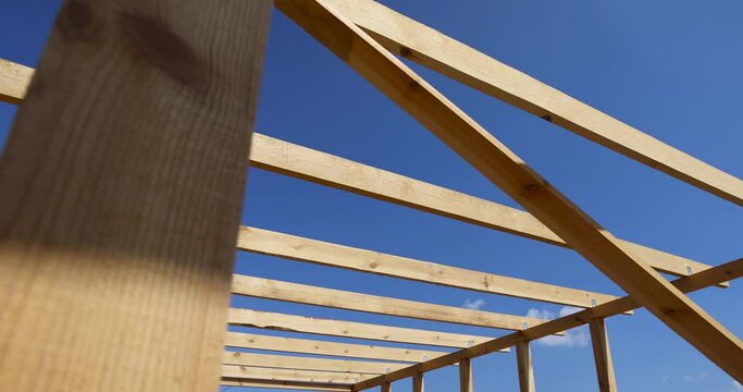 wooden beams used during the construction of the frame of the building, the manufacture of a new building using wood, against the blue sky