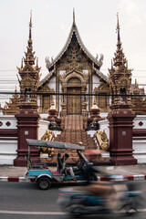 A buddist temple in Thailand, tuk tukt passing by