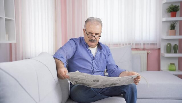 The old man is reading the newspaper.