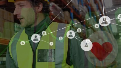 Animation of connected profile icons, graphs, heart shape over diverse workers talking in warehouse - Powered by Adobe