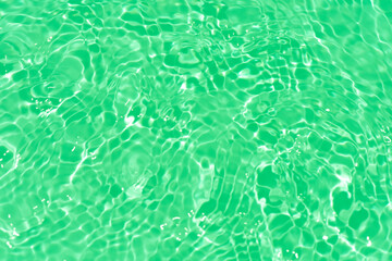 Blue water with ripples on the surface. Defocus blurred transparent blue colored clear calm water surface texture with splashes and bubbles. Water waves with shining pattern texture background.