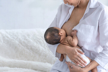 World breastfeeding week, newborn baby boy sucks the milk from mother breast, female breastfeeding son in her arms