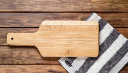 Cutting board over towel on wooden kitchen table. Top view