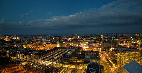 Central train station and city lights glow on summer night in Helsinki - 620375559