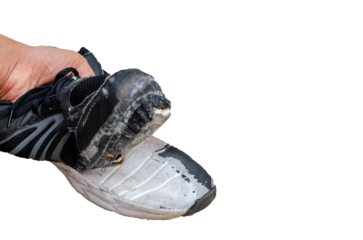 hand picks up the torn old black shoes on transparent background