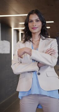 Vertical video of portrait of happy middle eastern businesswoman in casual office, slow motion