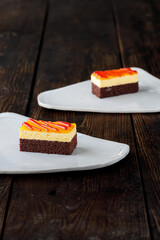 Delicious cake on plate on brown wooden table 