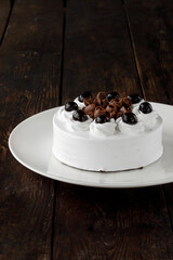 Delicious cake on plate on brown wooden table 