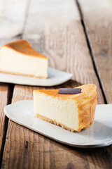 Delicious cake on plate on brown wooden table 
