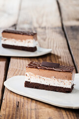 Delicious cake on plate on brown wooden table 