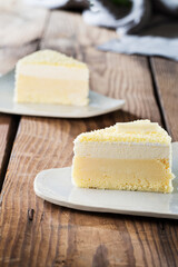 Delicious cake on plate on brown wooden table 