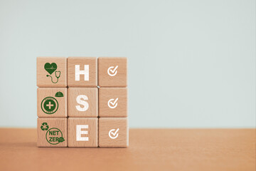 Obraz premium For Health, Safety and Environment concept, HSE text and icon with correct sign on stack of wooden cube block including copy space
