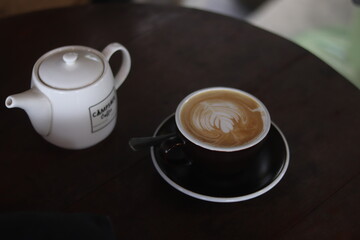 a cup of latte art on the wood