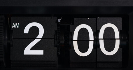 Flip clock displays the time as AM 2 o'clock white-lettered on a black background.