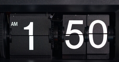 Flip clock displays the time as AM 1:50 o'clock white-lettered on a black background.