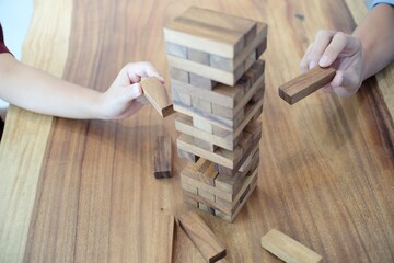Group of Friends playing blocks wood game on the table folded puzzle.