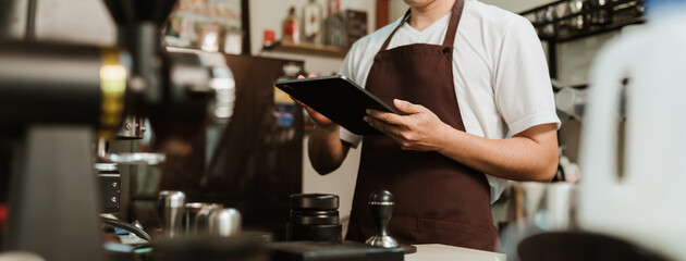 Banner ratio, Closeup hand of barista use digital tablet take orders service at coffee shop. SME...