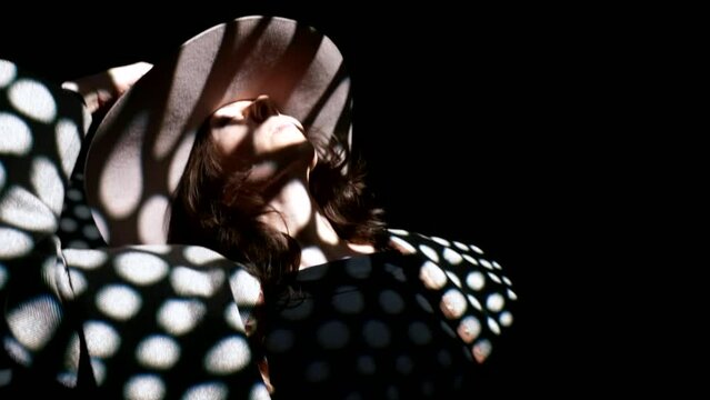 beautiful woman in darkness, taking her hat and dancing, delightful female figure