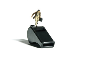 Miniature people toy figure photography. Whistle blower concept illustration. A businessman running...
