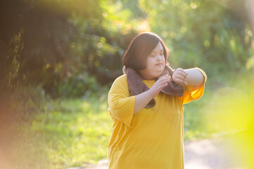 Girl with Down syndrome or autism looking at the time While walking outdoors in the park
