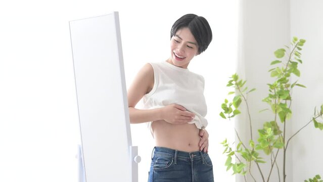 鏡を見てダイエット成功などの明るいイメージの女性　痩せて嬉しい動画