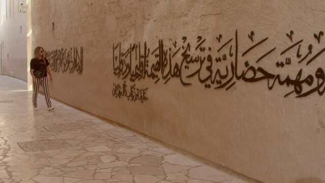 Portrait of a very beautiful white Caucasian woman. Al Fahidi is known for its Historical Neighborhood, with traditional buildings like 18th-century Al Fahidi Fort.