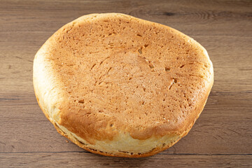 Homemade Ukrainian bread made from white wheat flour on a wooden table. Bottom of the loaf
