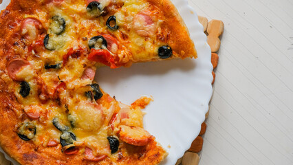 Homemade pizza on a plate. Cut off a piece of pizza.