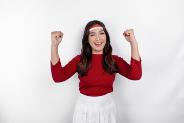 A young Asian woman with a happy successful expression wearing red top and flag headband isolated...