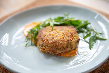 Indulge in a flavorful dinner with this crab cake recipe. Succulent crab cakes are paired perfectly with a fresh and peppery rocket salad, creating a delightful combination of tastes and textures. - 620413390